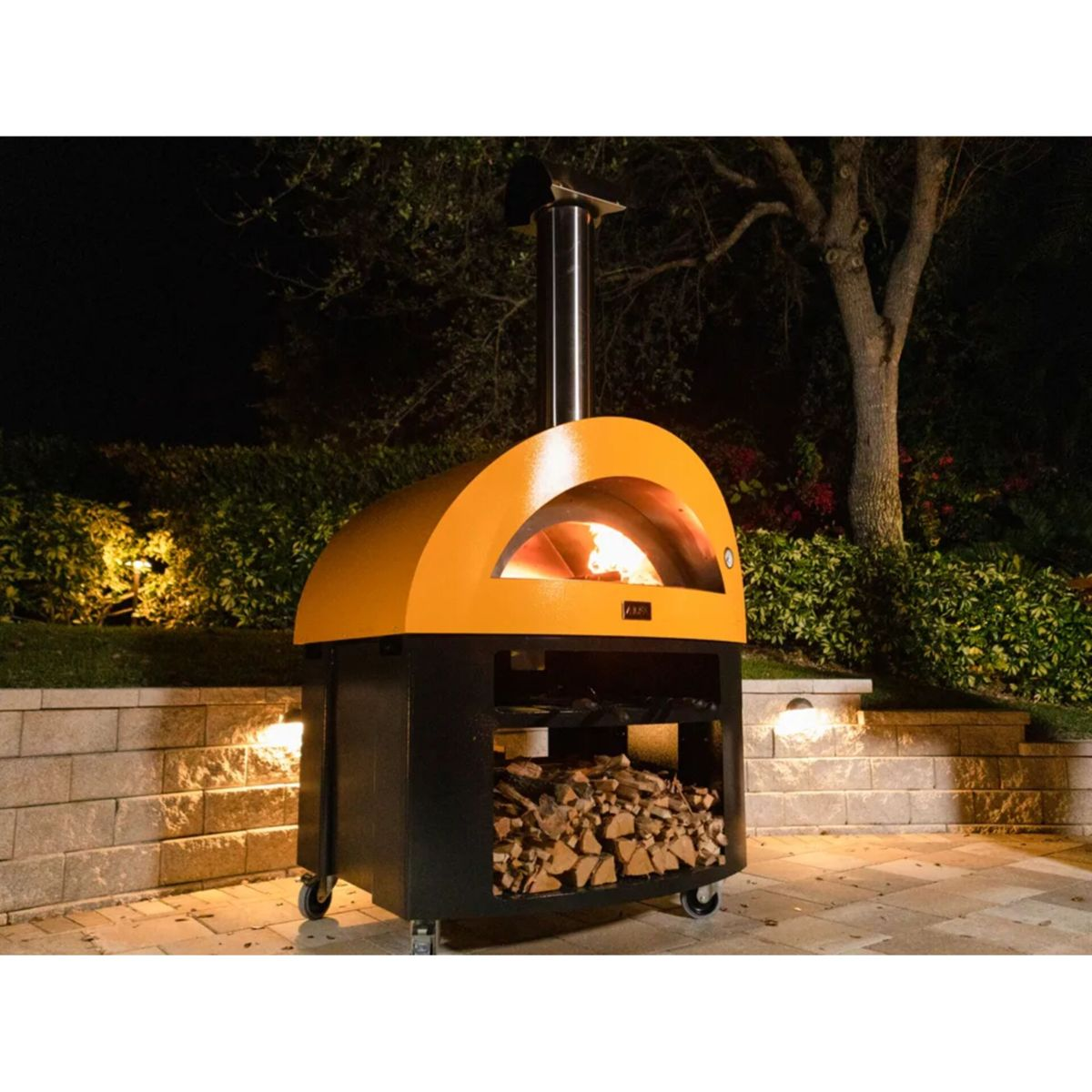 Ein orangefarner Pizzaofen mit brennendem Feuer, gelagertem Holz und Steinstufen.