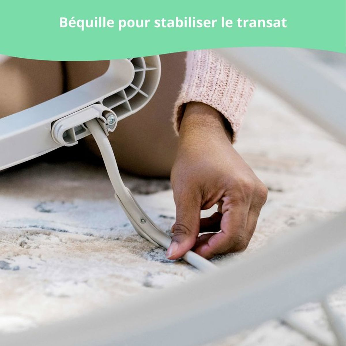 Eine Hand steckt ein Kabel in eine graue Halterung auf einem Teppich.