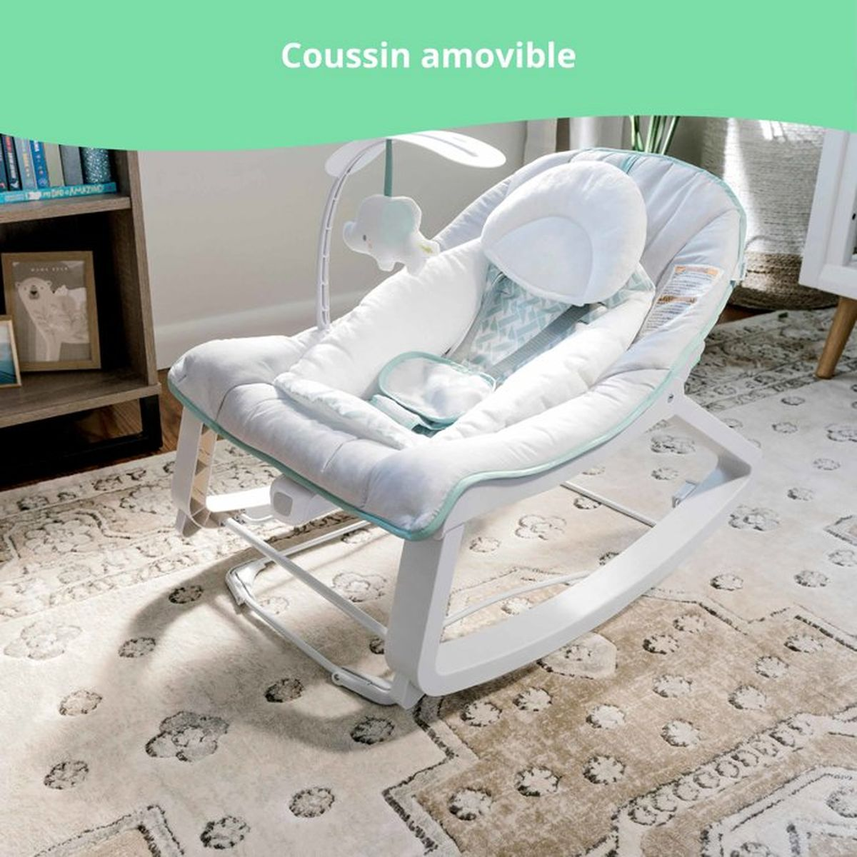 Ein weißer Babyschaukelstuhl mit Spielzeug und einem gemusterten Teppich.