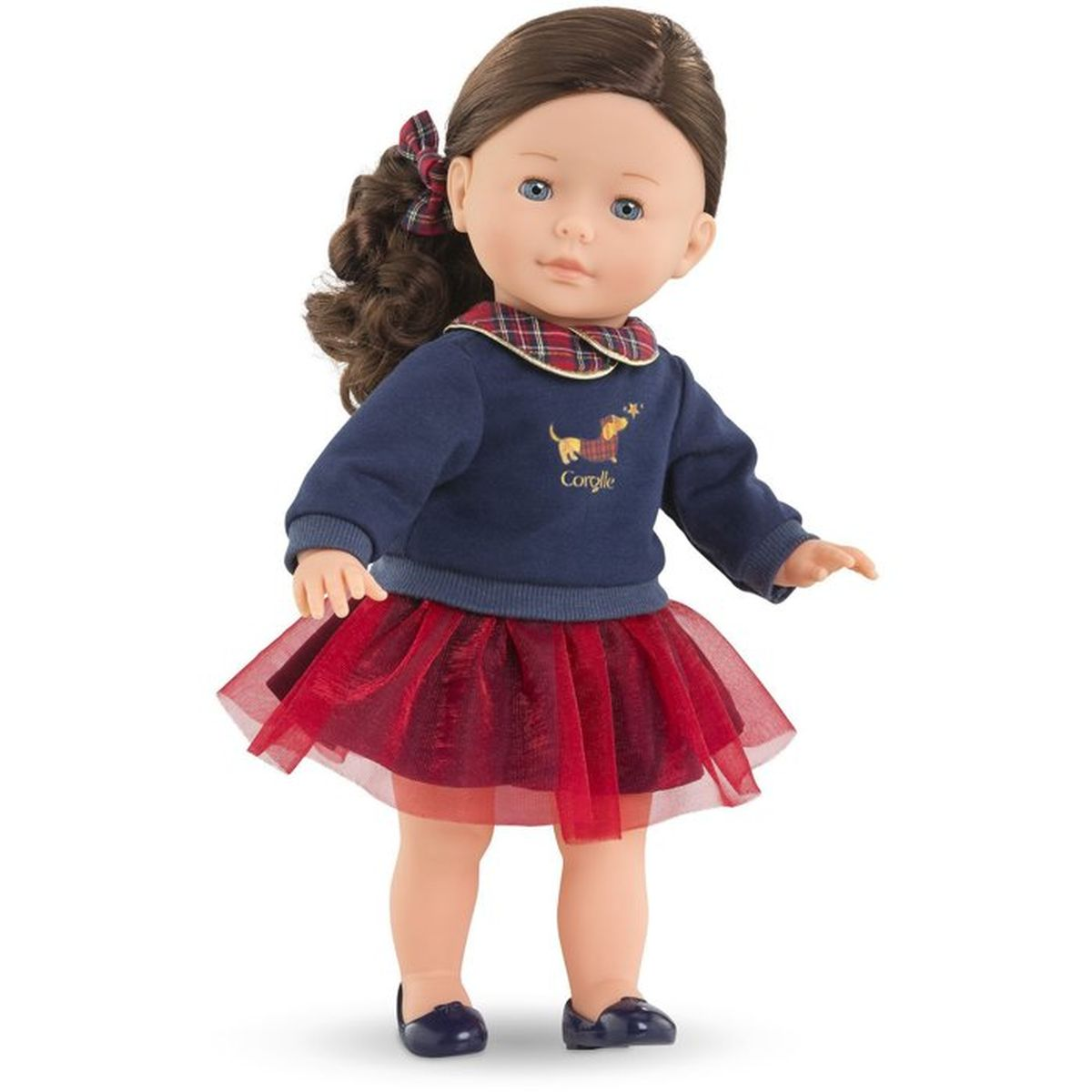 Eine Puppe mit braunen Haaren, blauem Pullover mit Hundemotiv und rotem Tutu-Rock.