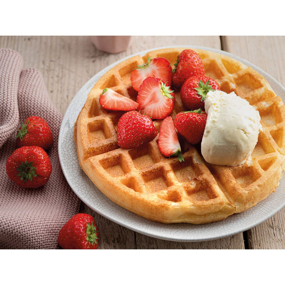 Üzeri çilek ve bir kaşık dondurma ile kaplı altın kahverengi waffle.