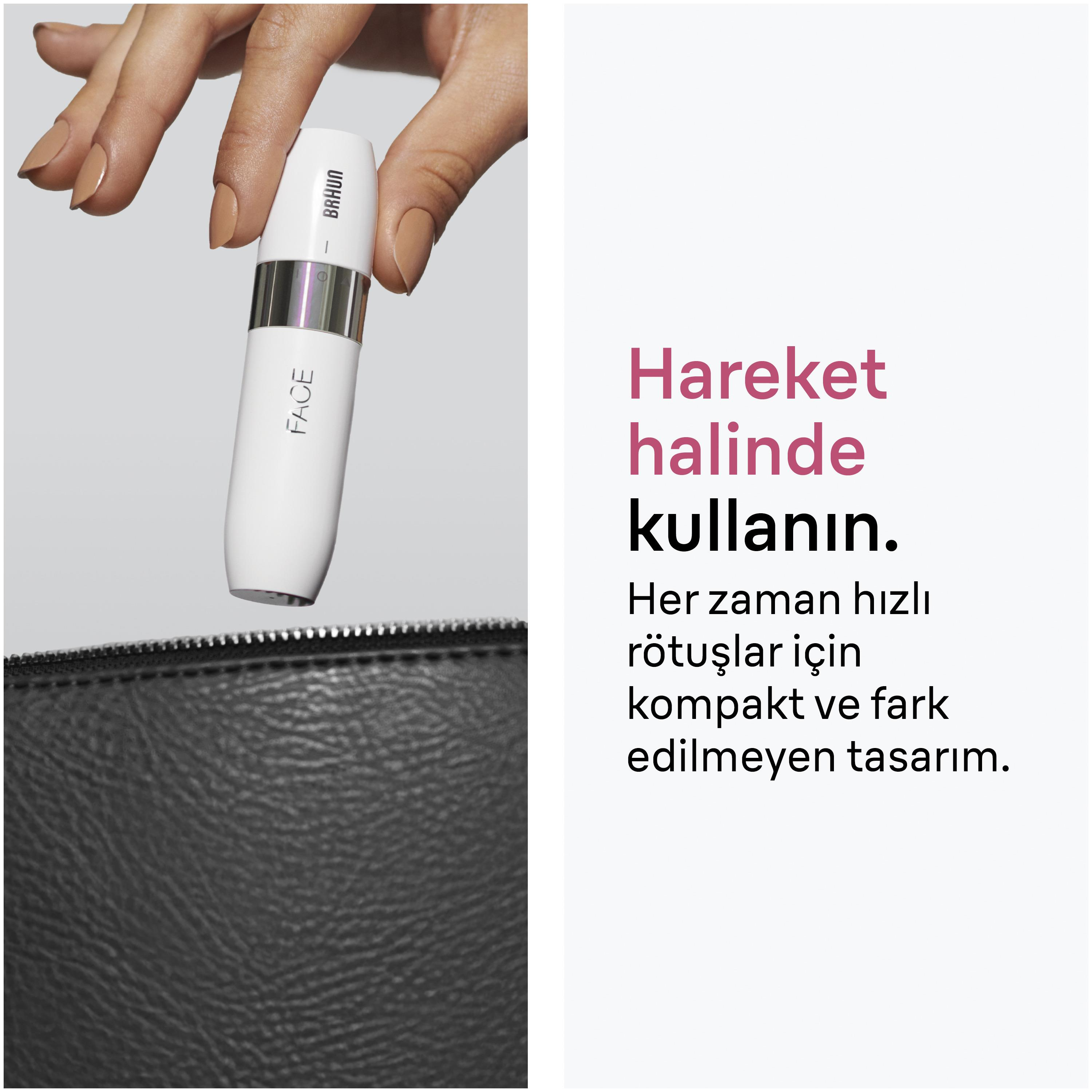 Bir el, siyah bir çantanın üzerinde beyaz bir güzellik cihazı tutuyor.