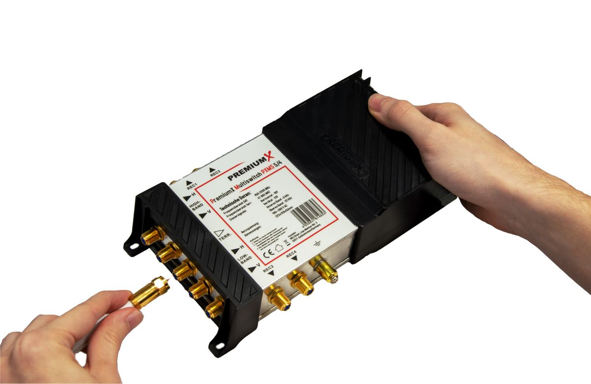 Eine Hand schließt ein Koaxialkabel an einen PremiumX Multiswitch an.