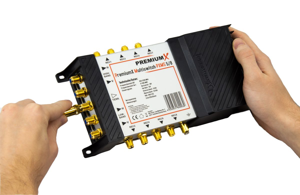 Eine Hand schließt ein Kabel an einen PremiumX Multiswitch PXMS 5/8 an.