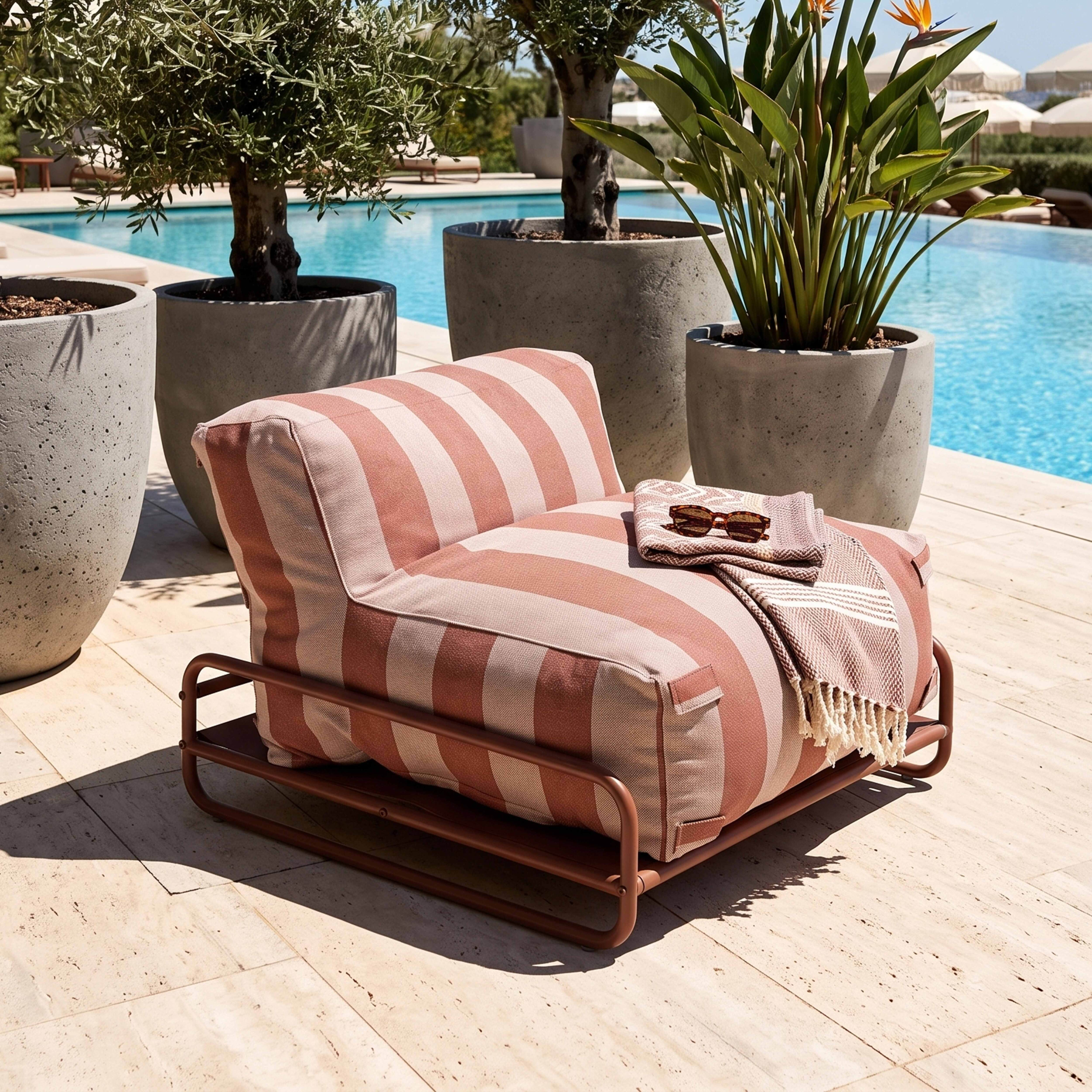 Gestreifter Sessel neben einem Pool mit Sonnenbrille und Decke.