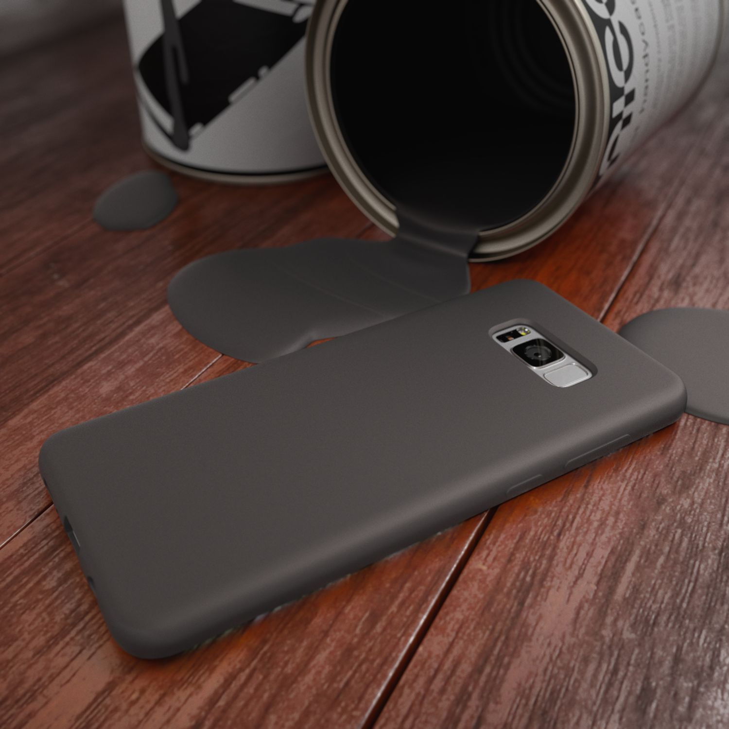 Graue Farbe tropft aus einer Dose auf ein Smartphone-Gehäuse auf Holzdielen.