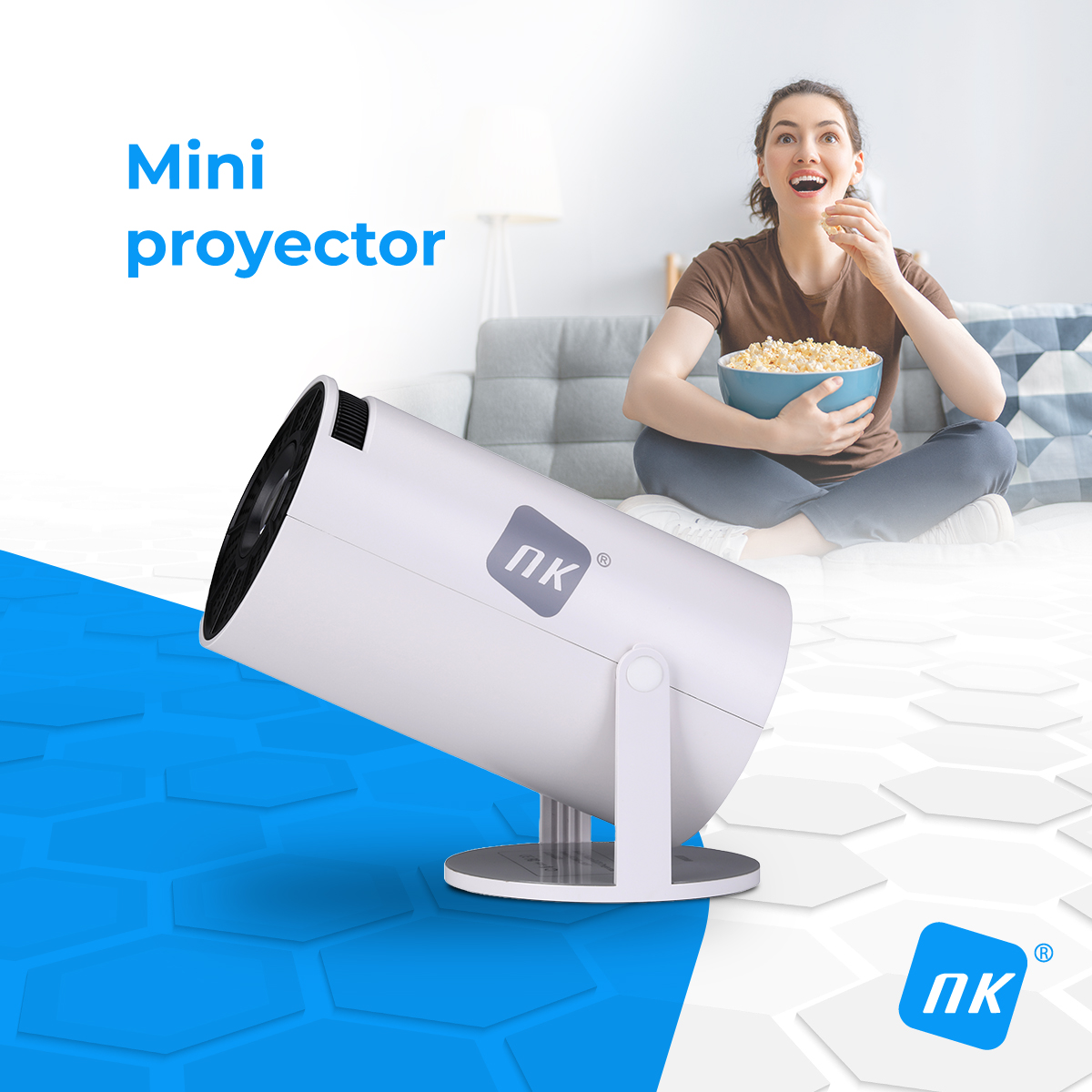Un mini proyector blanco en primer plano, una mujer come palomitas en un sofá.