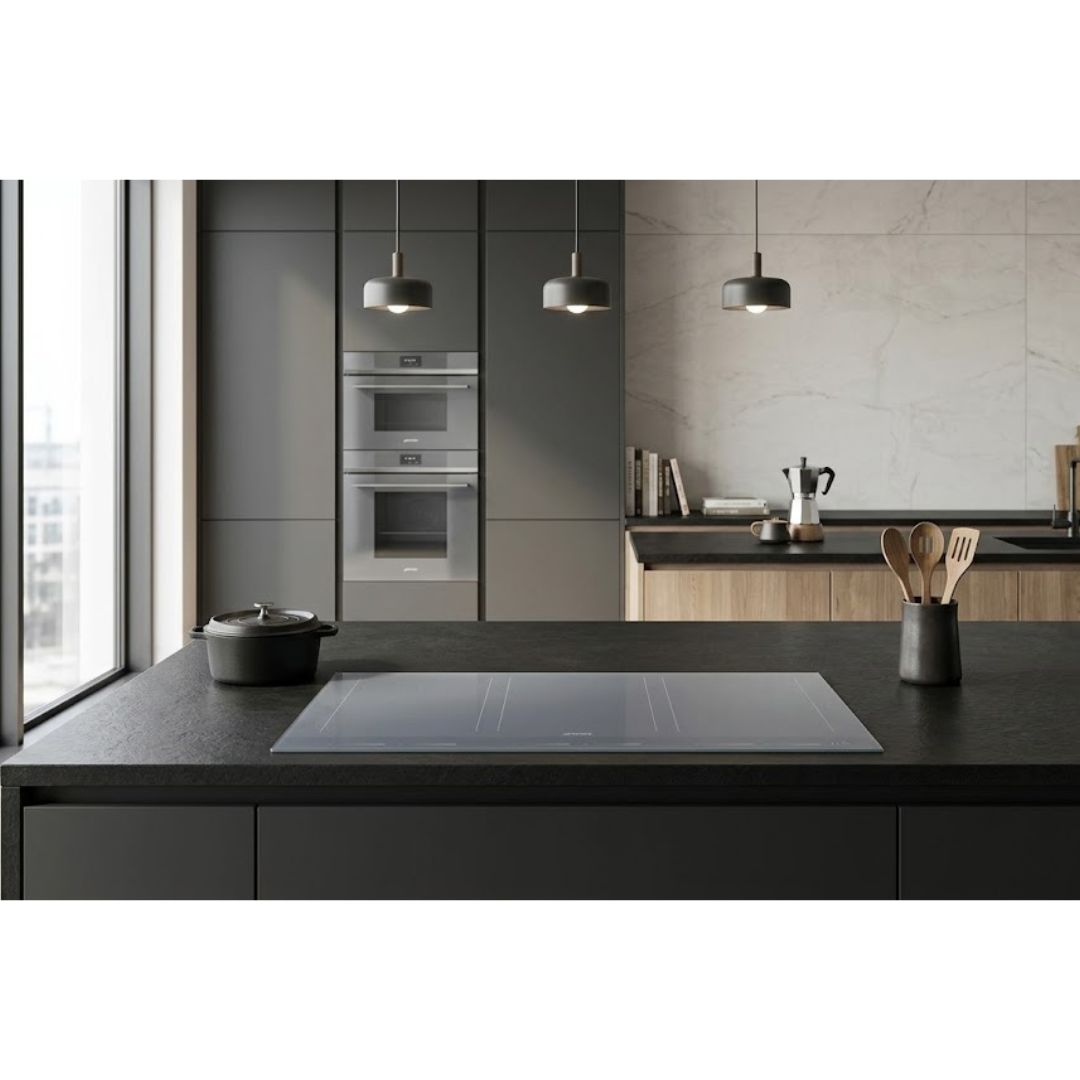 Cucina moderna con piano di lavoro nero, piano cottura a induzione e pentole.