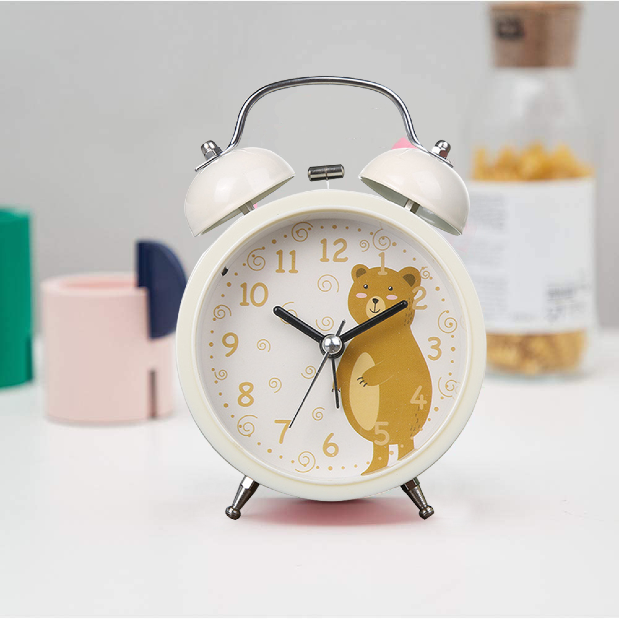 Ein weißer Wecker mit einem Bärenmotiv zeigt 10:09 Uhr an.