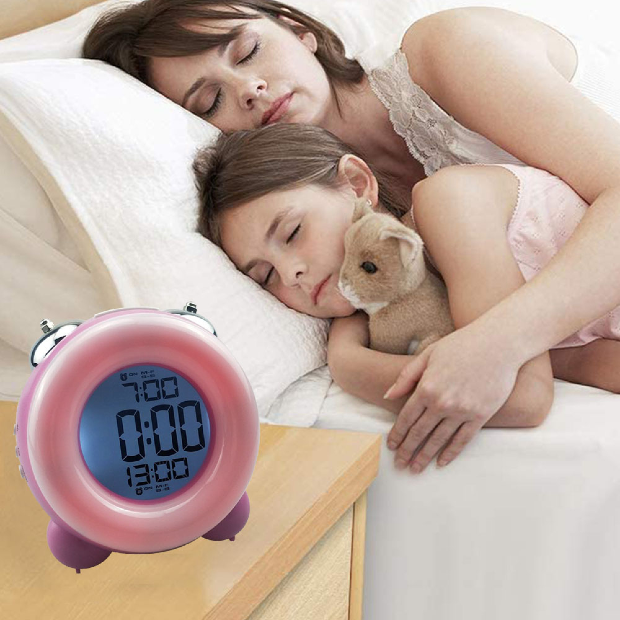 Mutter und Kind schlafen, ein rosa Wecker steht daneben.