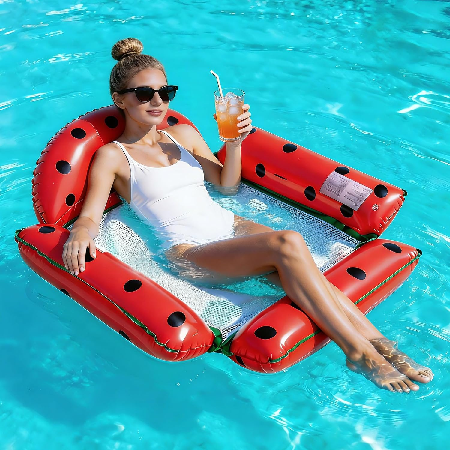 Frau in weißem Badeanzug schwimmt auf aufblasbarem Ladybug-Floß mit Getränk.