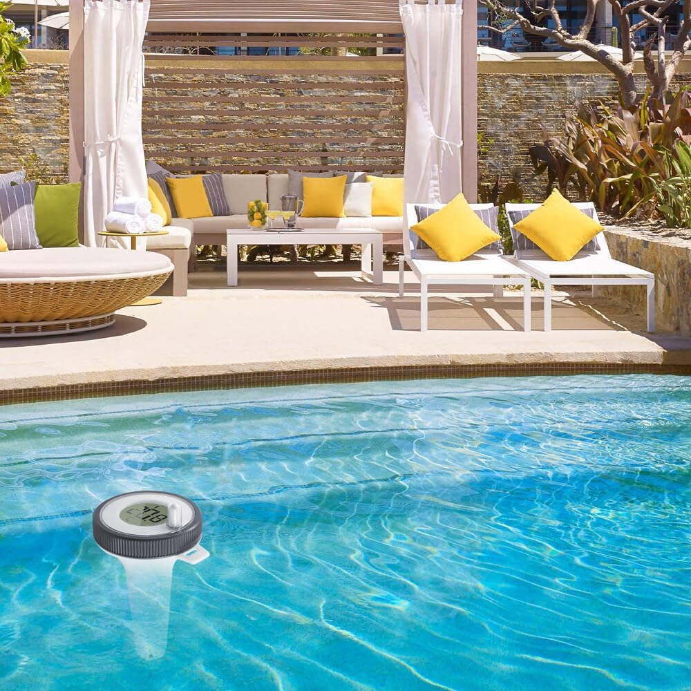 Ein Poolthermometer mit digitaler Anzeige schwimmt in blauem Wasser neben einer Lounge-Ecke.