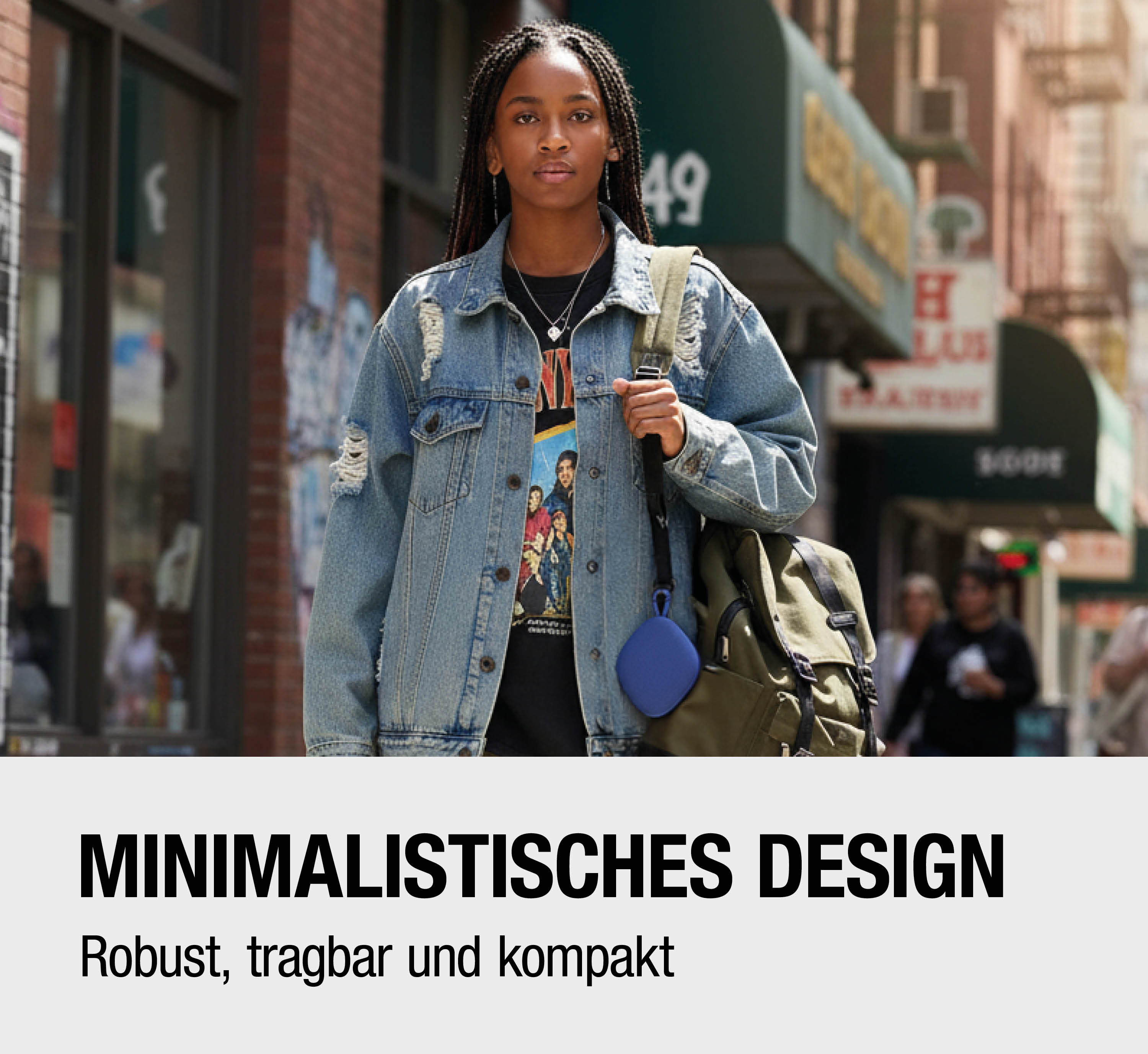 Junge Frau im Jeansjacke mit geflochtenen Haaren, hält blauen Lautsprecher.