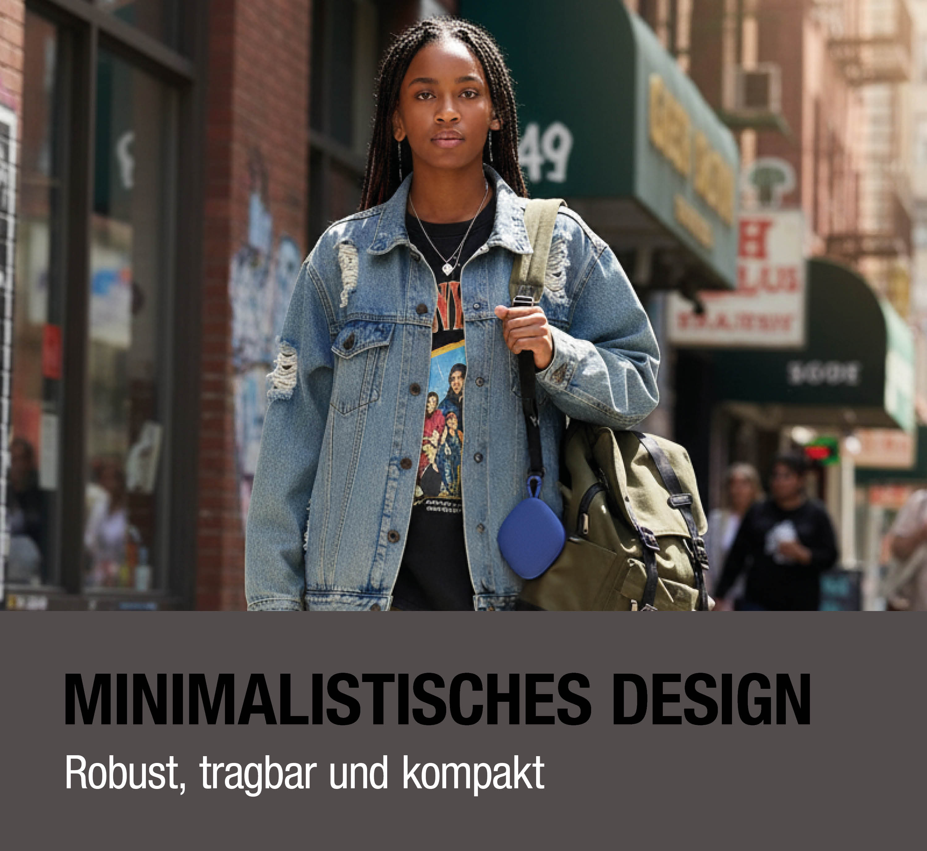Frau mit Zöpfen trägt Jeansjacke, hält blauen Lautsprecher und Rucksack.