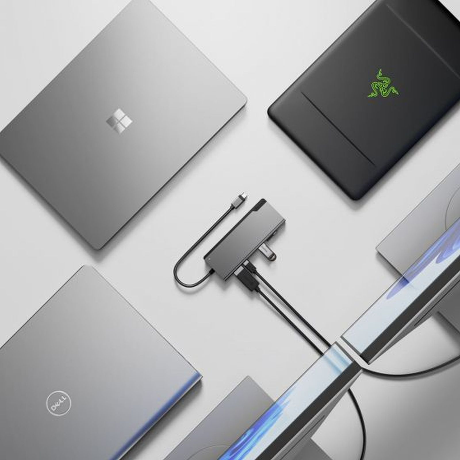 Laptop e hub USB su sfondo bianco, con una striscia luminosa.