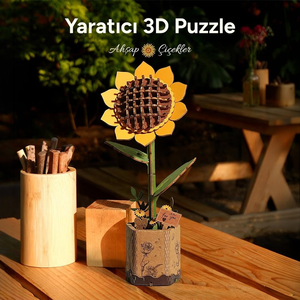 Un puzzle 3D de tournesol dans un pot est sur une table en bois.