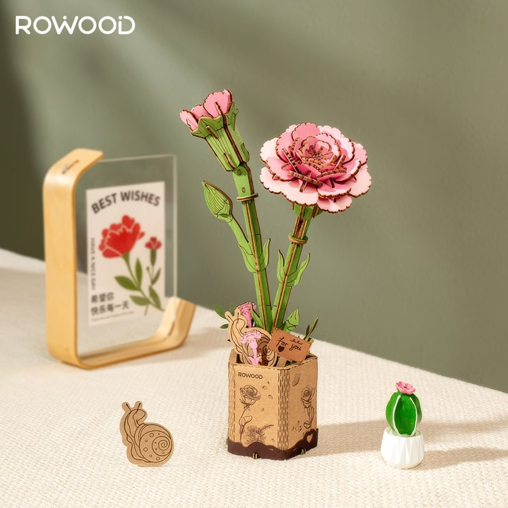 Modelo de flor de madera en un jarrón con decoraciones, incluyendo un caracol y un cactus.