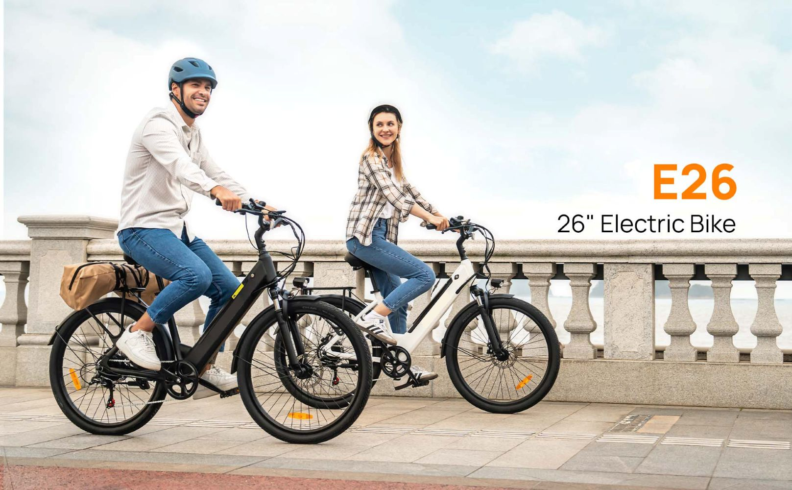 Hombre y mujer montando bicicletas eléctricas junto al mar. Cielo azul, paseo.
