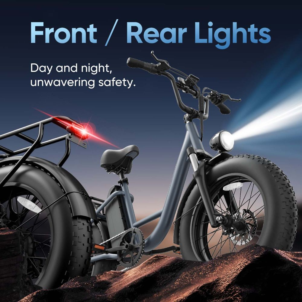 Bicicleta eléctrica gris con luces delantera y trasera encendidas, sobre terreno rocoso.