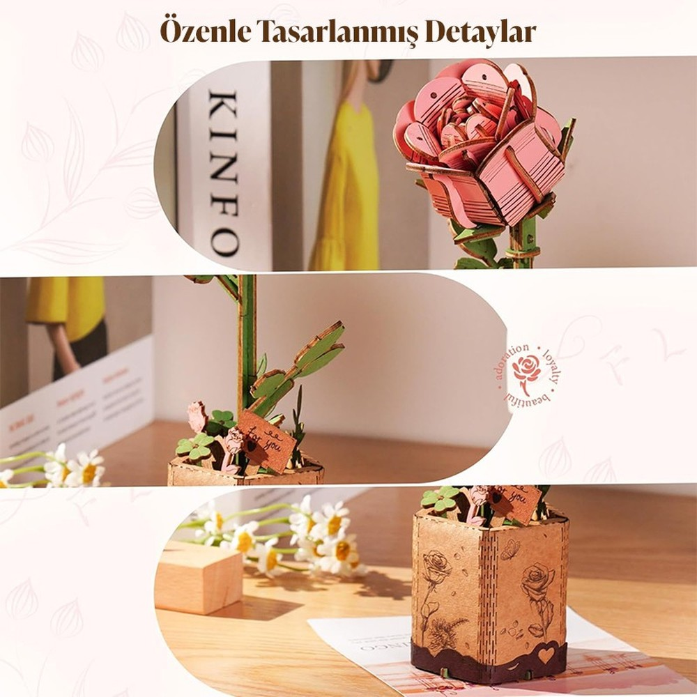 Ein rosafarbener Holzrosen-Bausatz mit Blüten und Blättern auf einem Tisch.