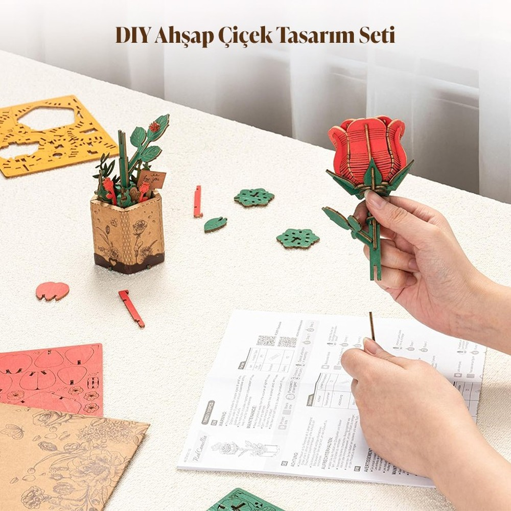 Kit de bricolage rose en bois avec instructions, outils et pièces sur table.