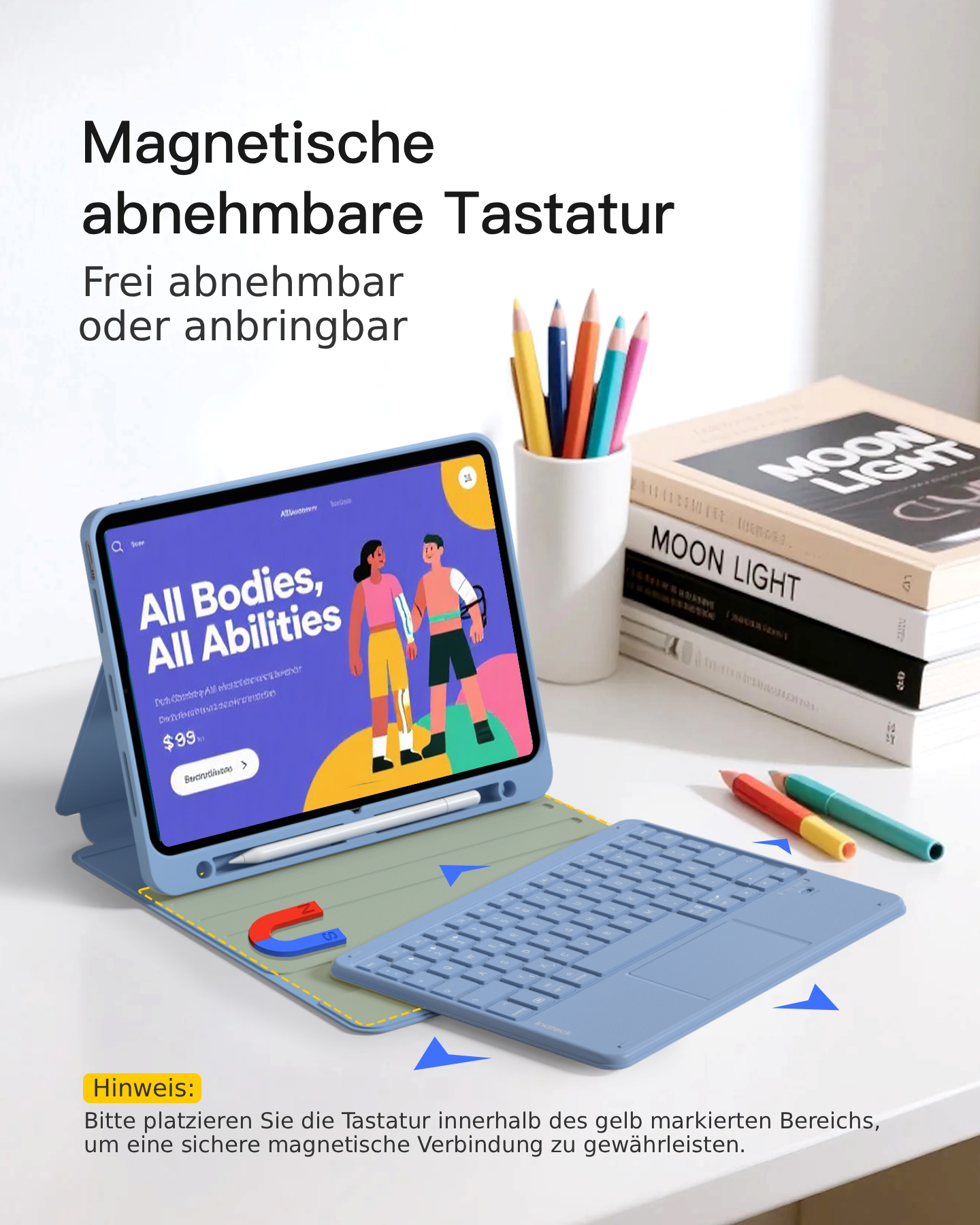 Ein Tablet mit abnehmbarer Tastatur, Stiften und Büchern auf einem Schreibtisch.