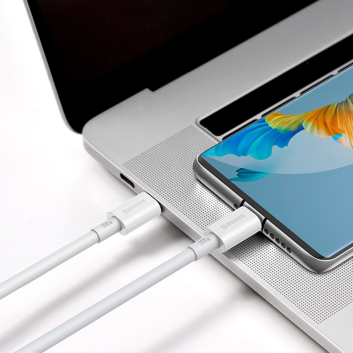 Weißes Baseus-Ladekabel an Laptop und Telefon angeschlossen.