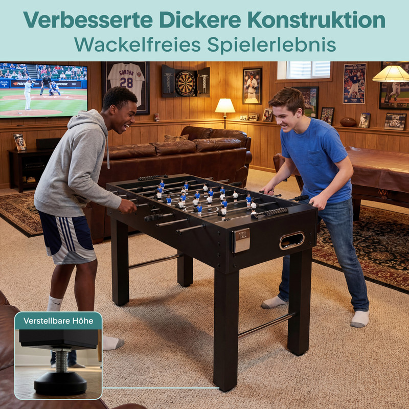 Zwei Jungen spielen Tischfußball in einem Wohnzimmer mit Holzwänden und einem Fernseher.