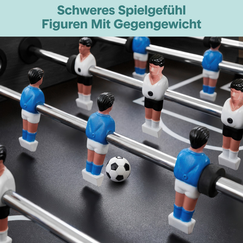 Tischfußballfiguren: blaue und weiße Spieler auf silbernen Stangen, Ball liegt auf dem Spielfeld.