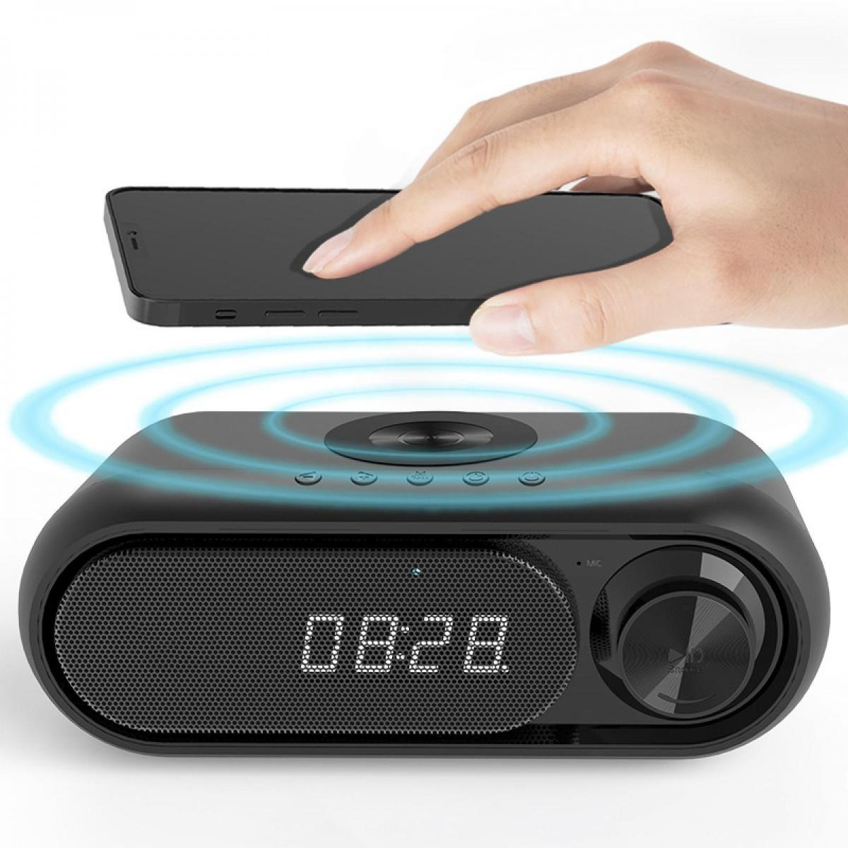 Eine Hand legt ein Smartphone auf einen schwarzen Lautsprecher mit digitaler Zeitanzeige.