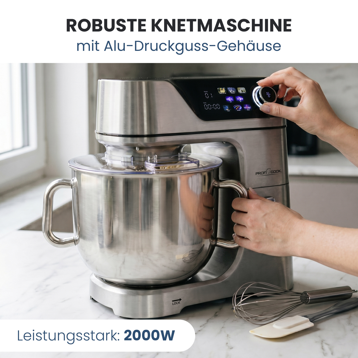 Eine Küchenmaschine aus Metall mit Schüssel. Eine Hand dreht am Knopf.