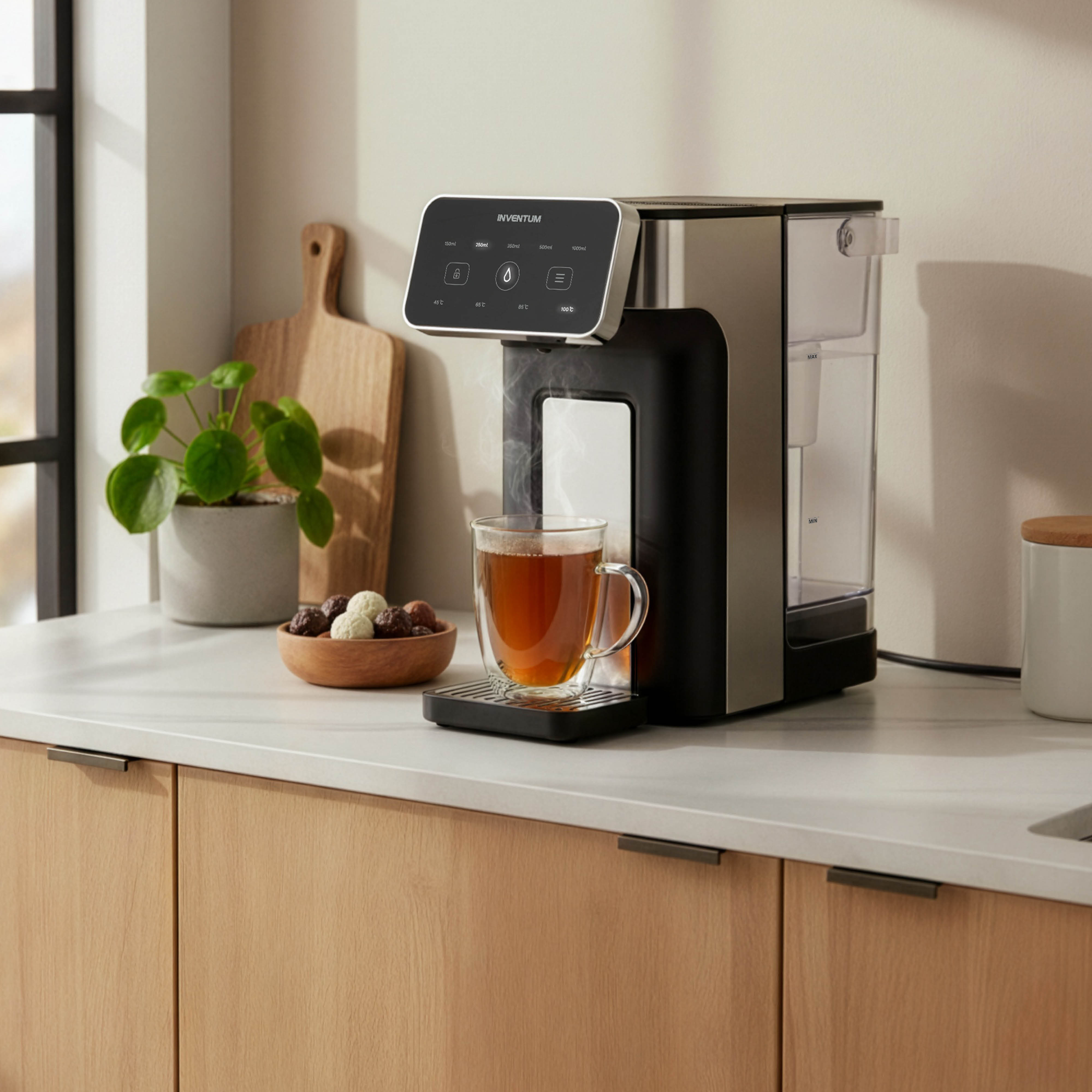 A water dispenser pours hot tea into a glass on a countertop.