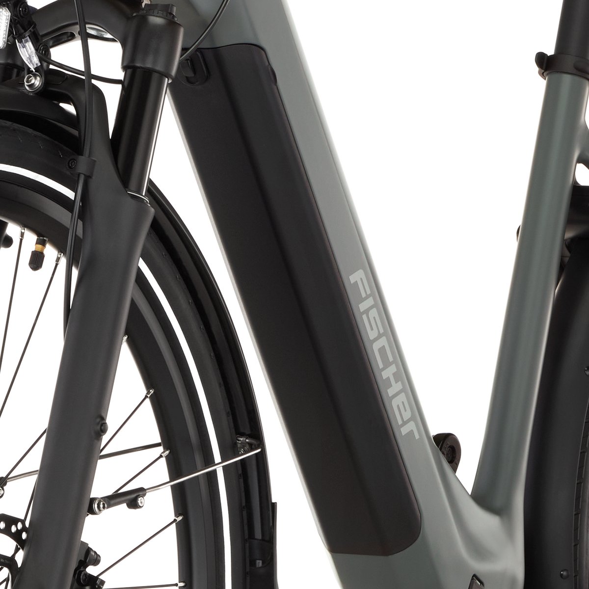 Nahaufnahme eines grauen E-Bikes. Der Rahmen mit der Aufschrift FISCHER ist sichtbar.
