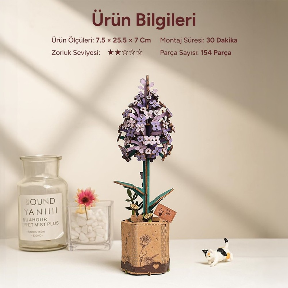 Un modèle de fleur violette avec un pot, un vase en verre et une figurine de chat.
