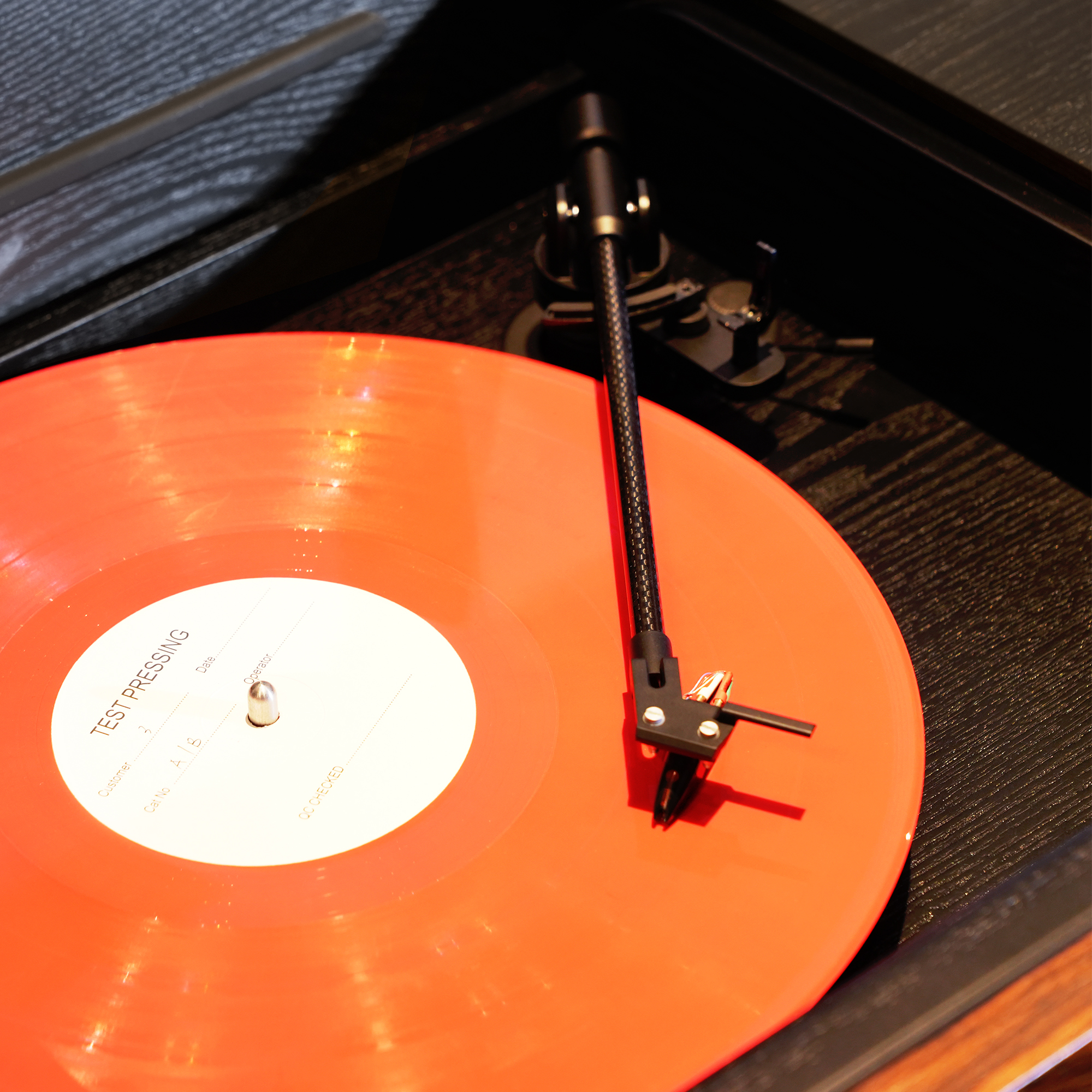 Plak çalarda turuncu vinil test baskısı ve ton kolu.