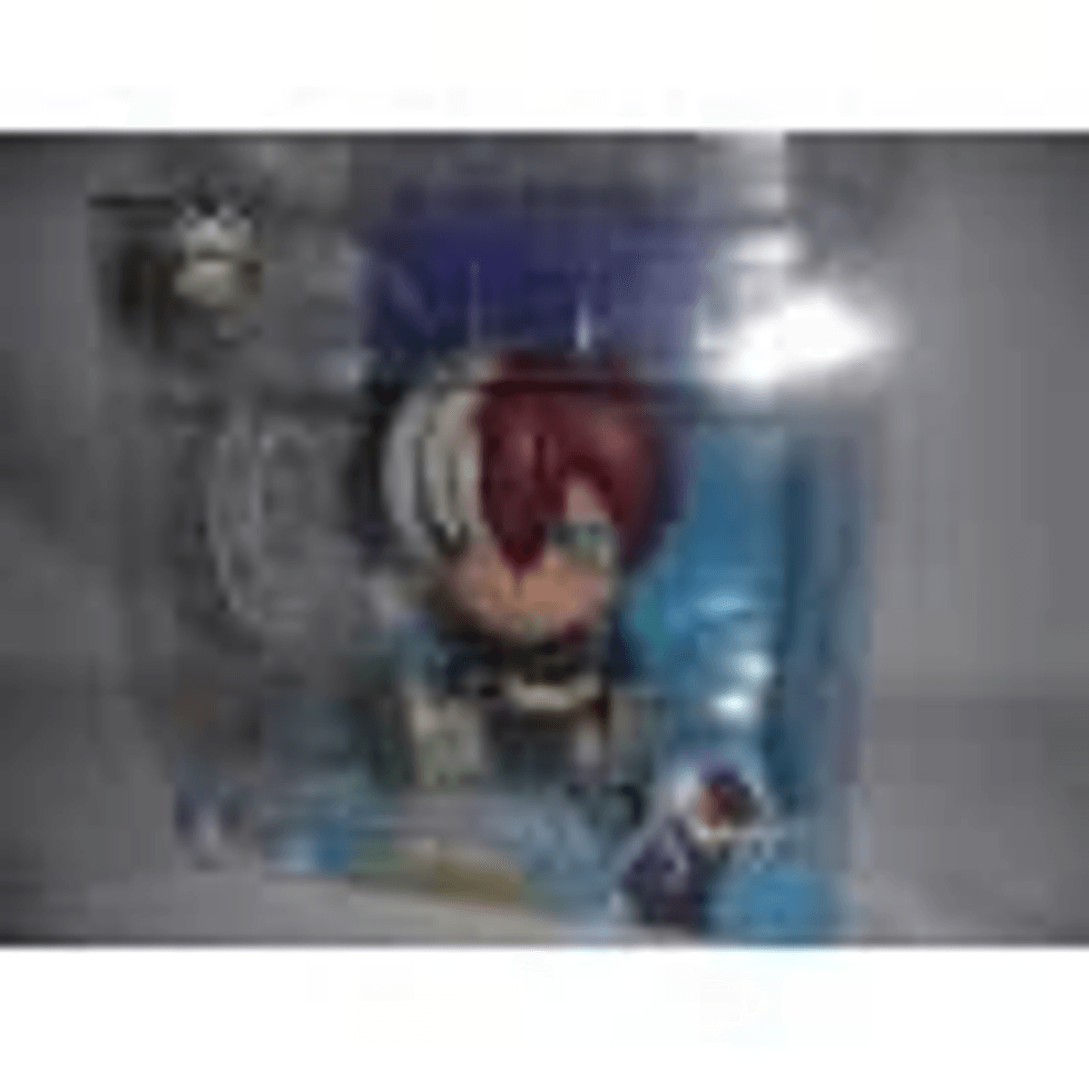 Una pequeña figura de Todoroki en un empaque transparente con efectos azules.