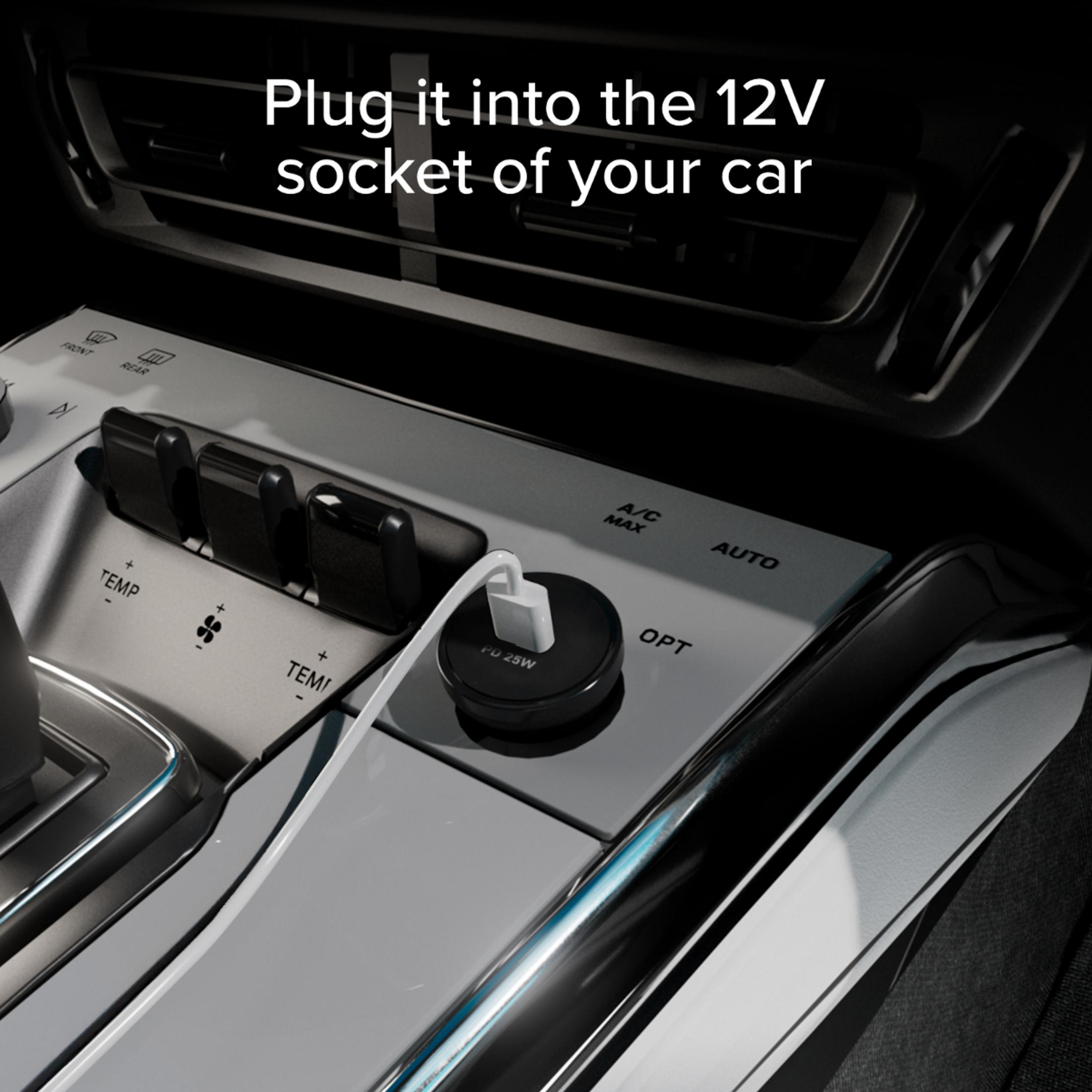 Un cable USB-C blanco está enchufado en un enchufe de 12V negro en un coche.