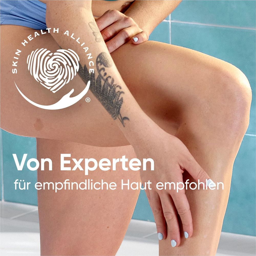 Primo piano di gambe con tatuaggio e logo.