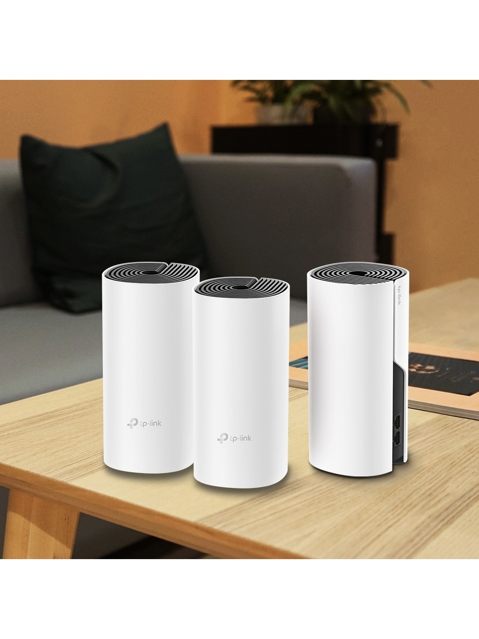 Tre unità Wi-Fi mesh TP-Link Deco bianche su un tavolo di legno.