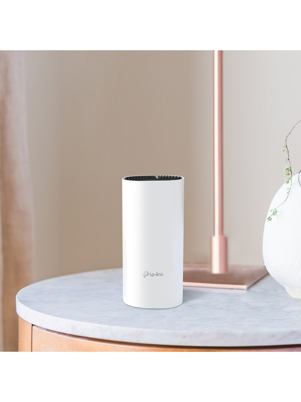 Un router TP-Link bianco è seduto su un tavolo di marmo accanto a un vaso.