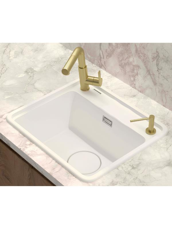 Mermer üzerinde altın musluk ve sabunluklu beyaz lavabo.