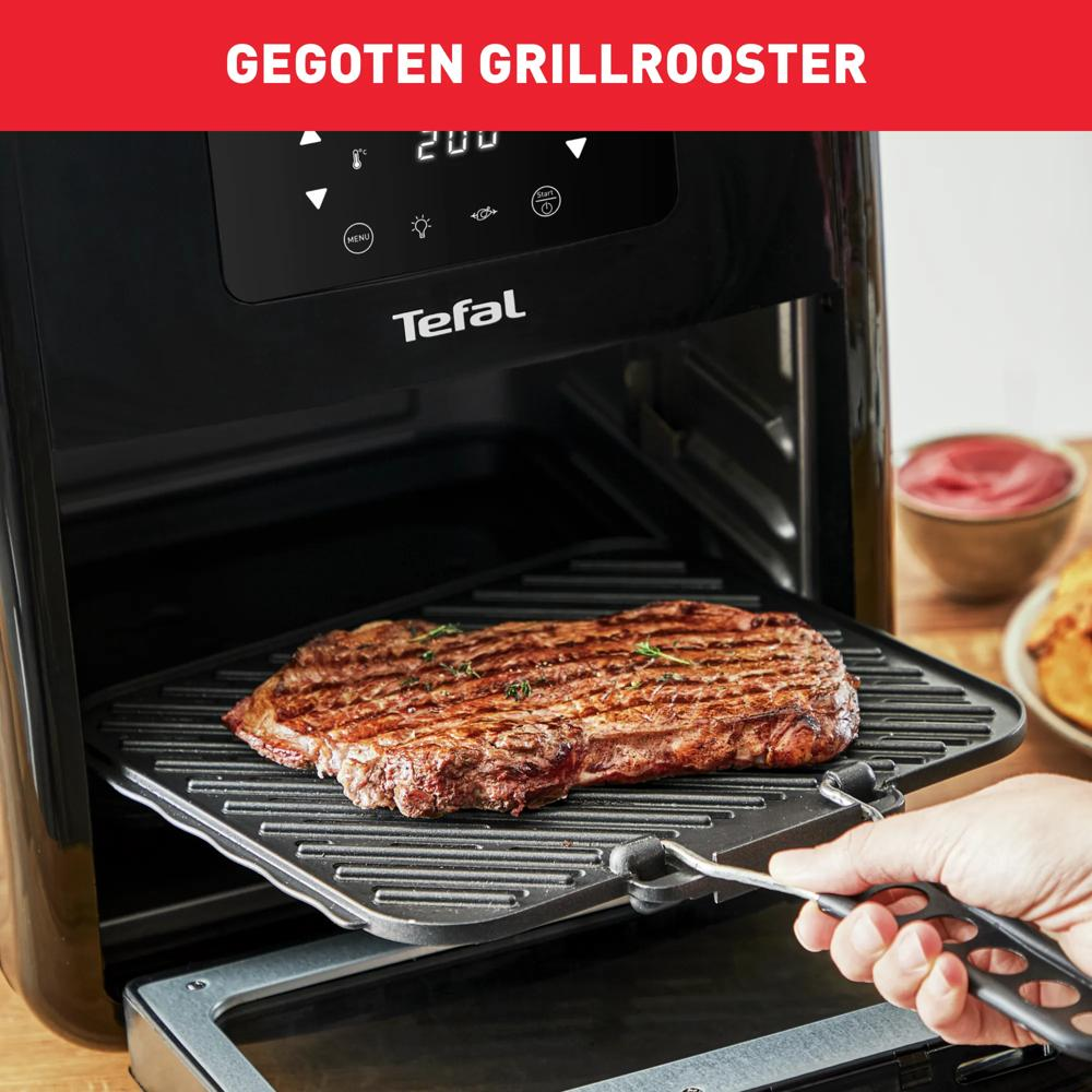 A steak on a grill rack inside a black Tefal grill. A bowl of ketchup is in the background.