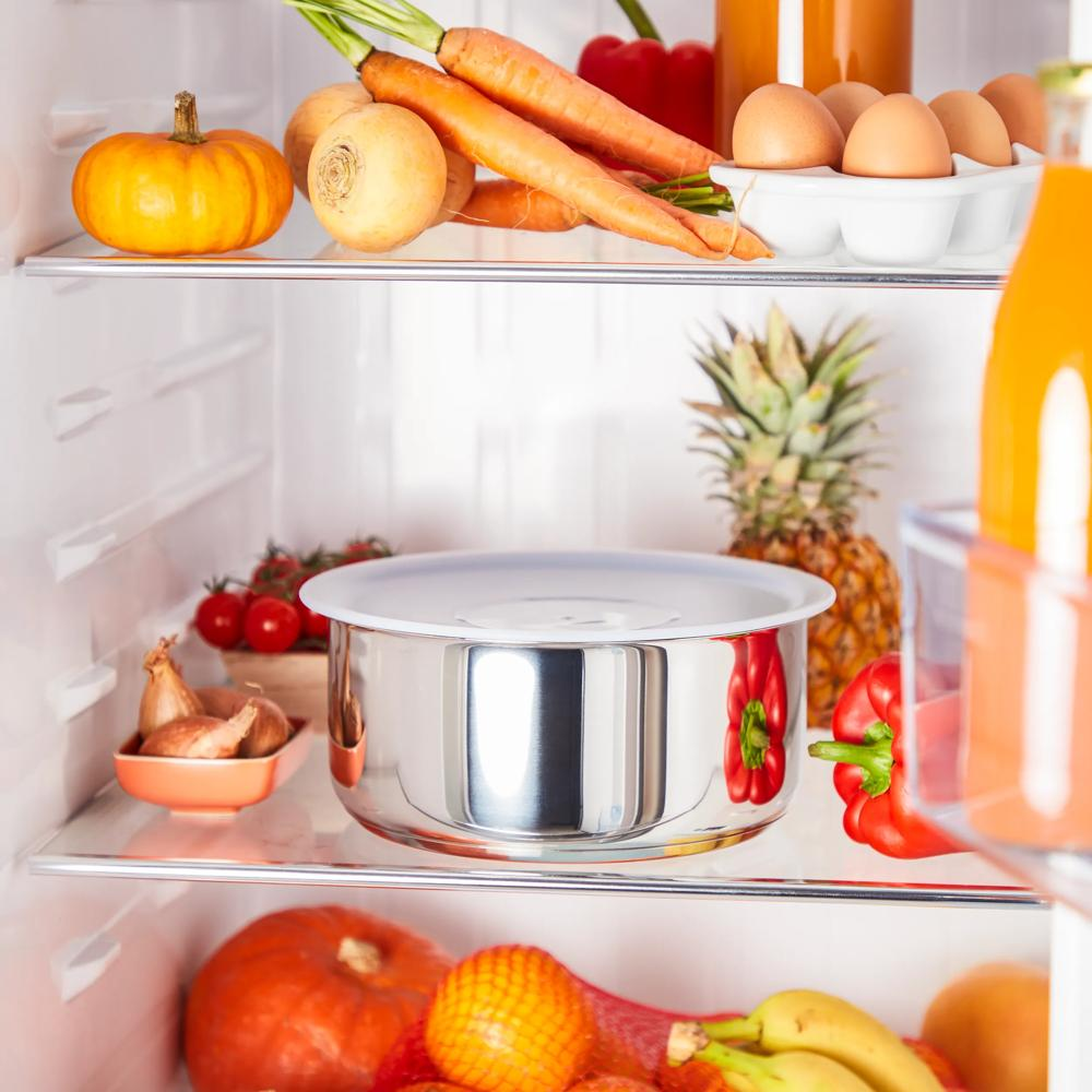 Ein offener Kühlschrank mit Obst und Gemüse auf den Einlegeböden.