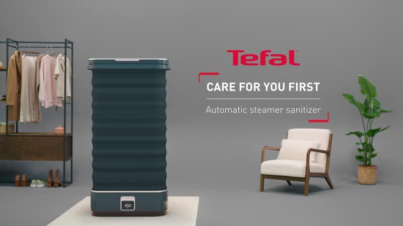 Un vaporizzatore Tefal blu scuro accanto a una poltrona e una pianta.