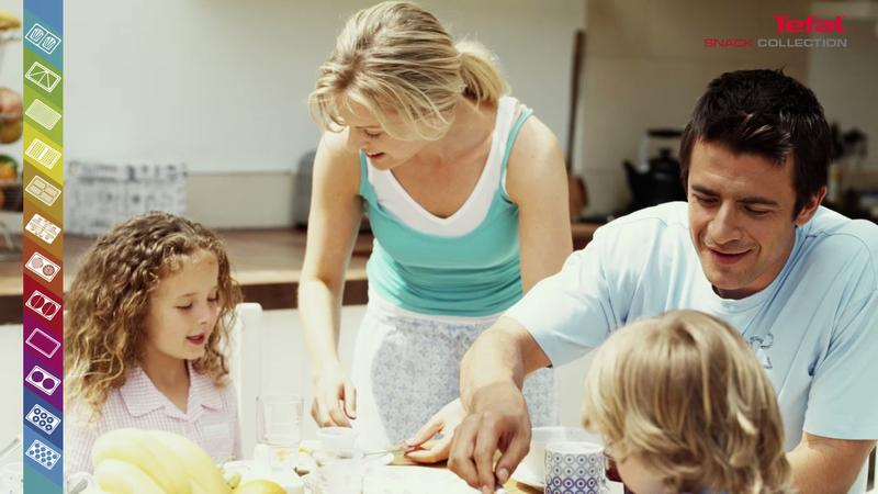 Famiglia mangia all'aperto, padre taglia cibo, madre e figli guardano.