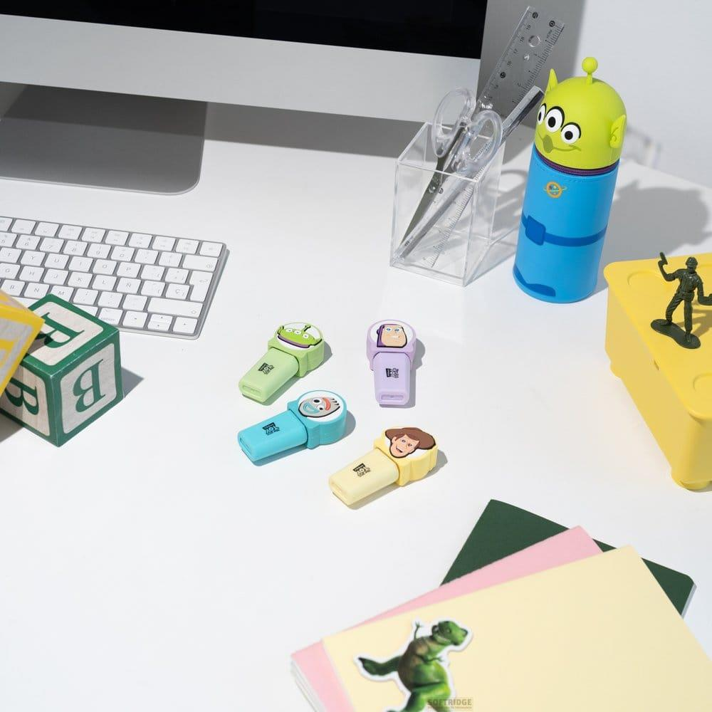 Schreibtisch mit Computertastatur, Bleistiften, Schere, Lineal und Spielzeugfiguren.
