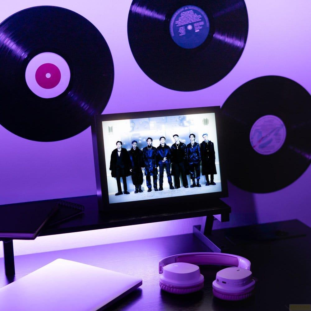 Ein Monitor mit einer Gruppe von Männern, umgeben von Schallplatten und Kopfhörern.