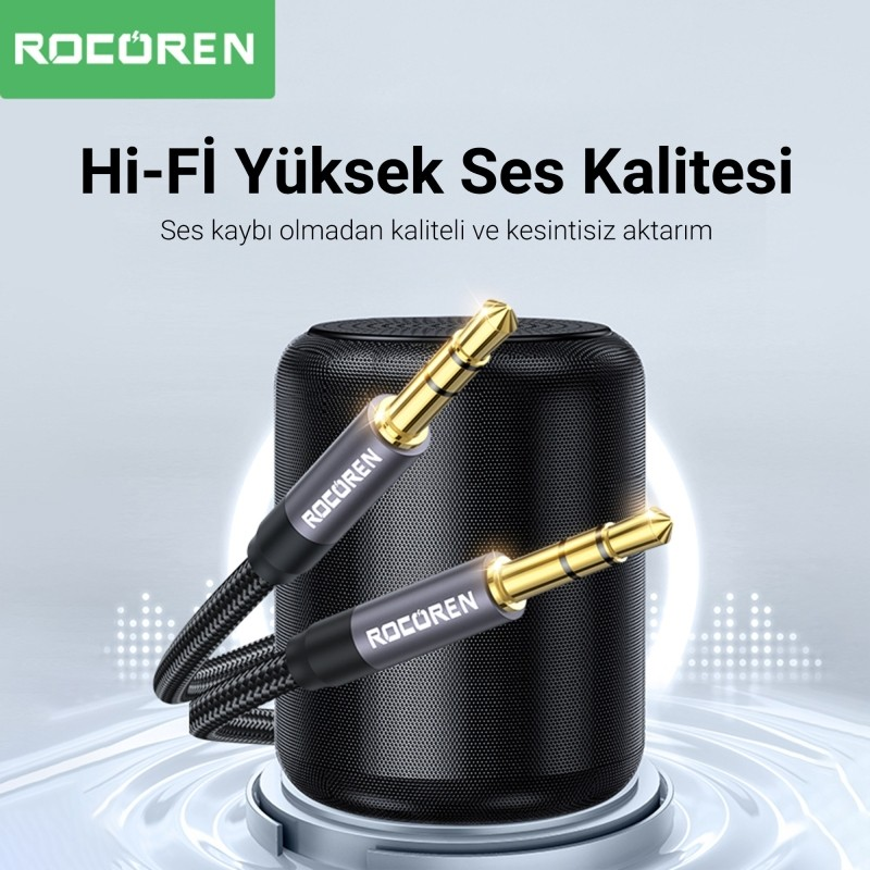 Siyah hoparlör önünde Rocoren logolu iki altın 3,5 mm ses fişi.
