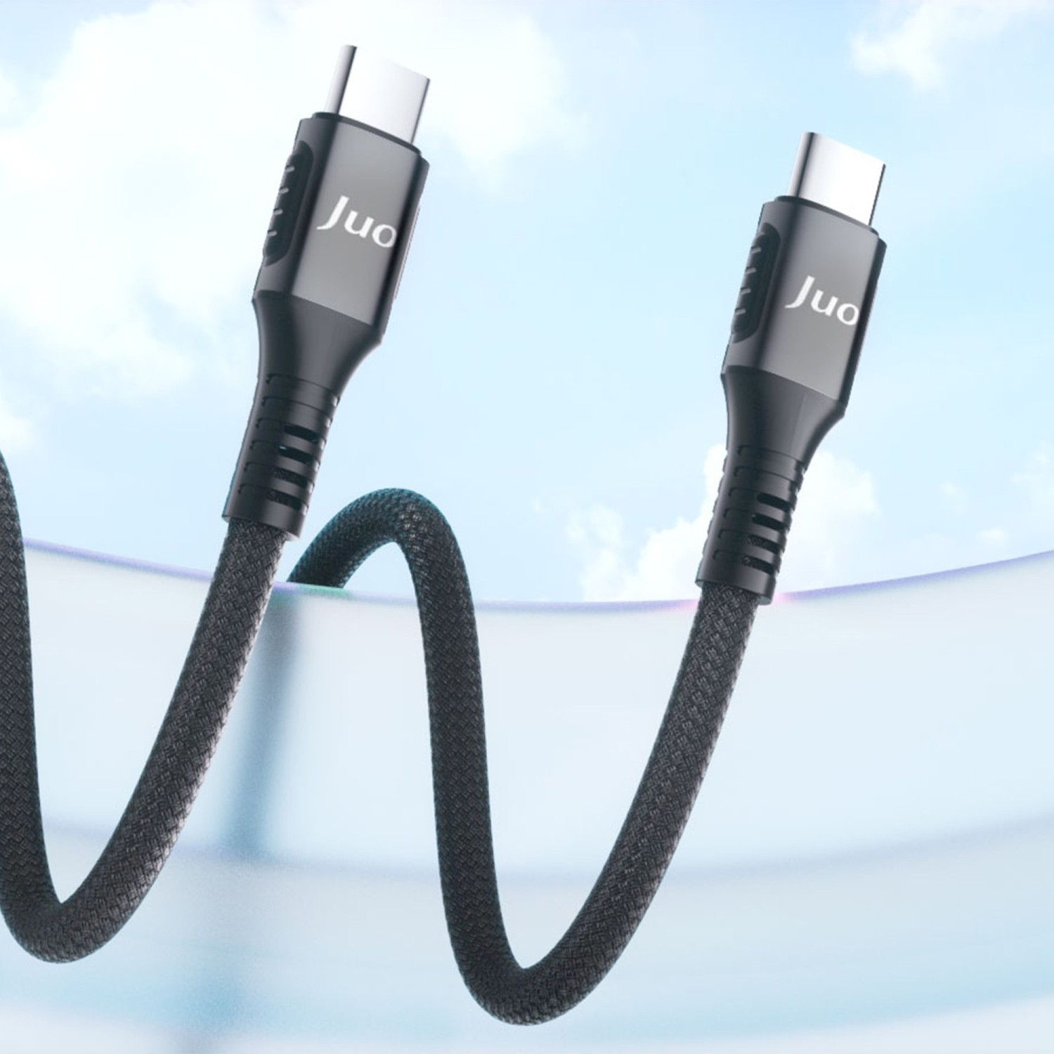 Juo logolu siyah USB-C kablosu, mavi gökyüzü önünde.