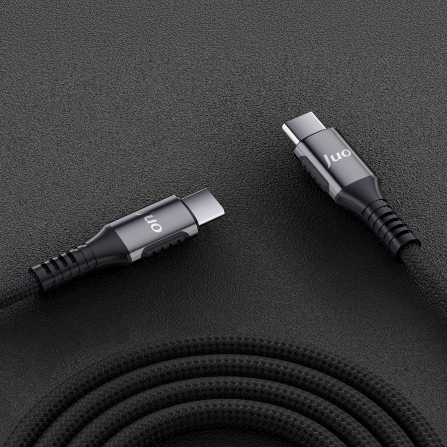 Koyu dokulu yüzeyde gümüş konektörlü iki siyah USB-C kablosu.